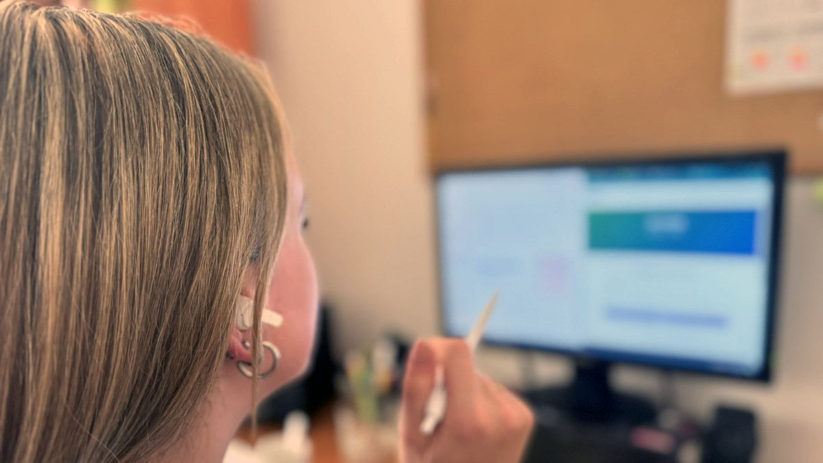 Žena se sluchátky sleduje online kurz MADIO